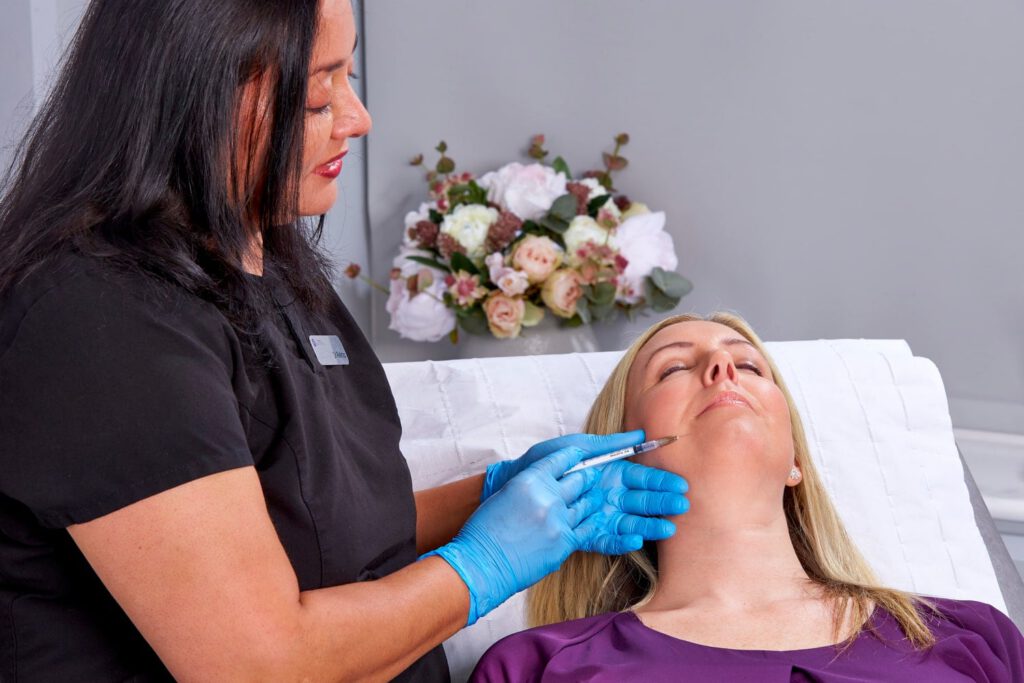 A woman undergoing dermal filler treatment for facial enhancement and rejuvenation