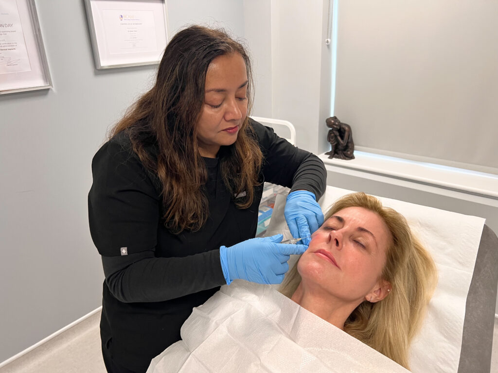 Dr. Rekha Tailor injecting a patient's face