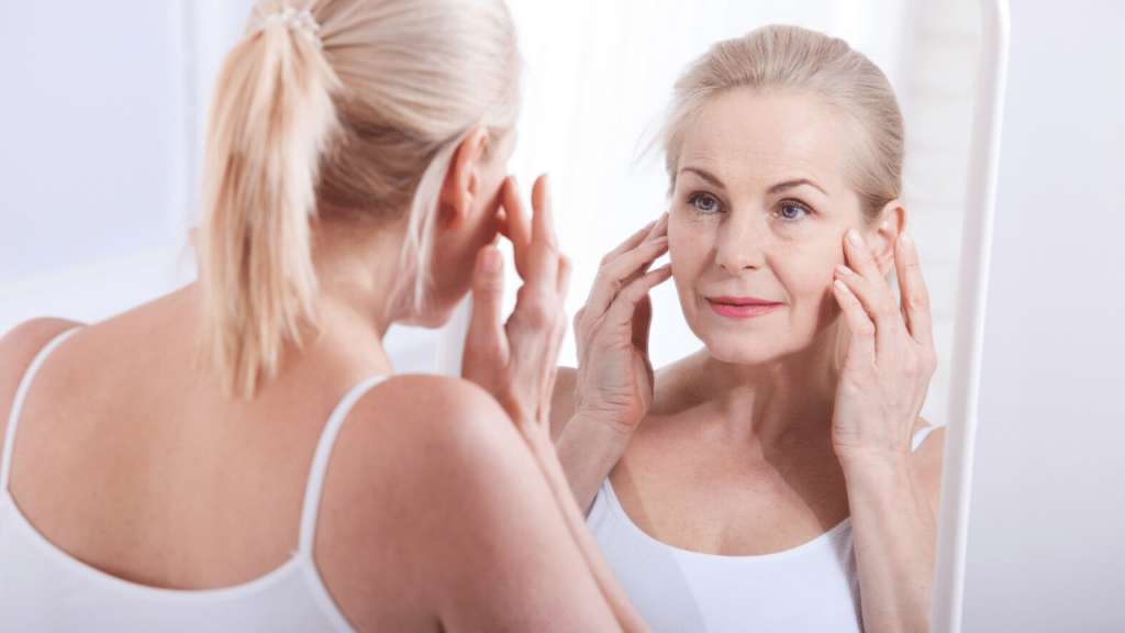 woman looking at her face in the mirror